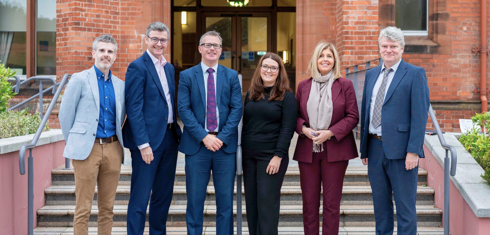 six people standing outside riddel hall